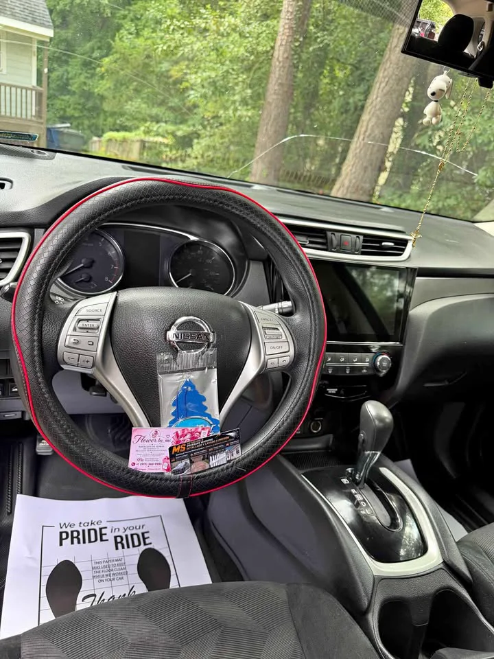 A finished interior — steering wheel, dash and centre console clean, a paper floor mat reading We take pride in your ride
